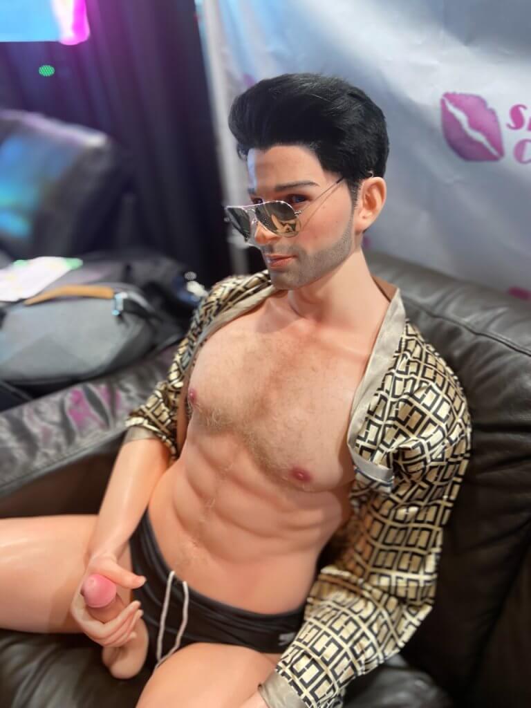 A sexy male sex doll wears aviatars and shows off his very realistic penis.