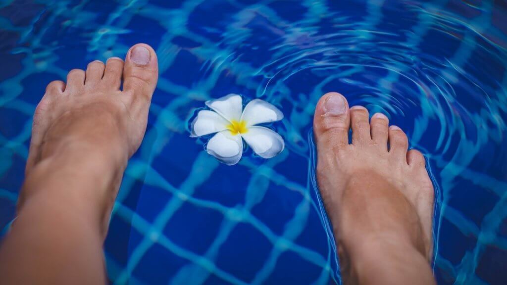 Feet in a pool shown alongside an article describing what is a foot fetish.